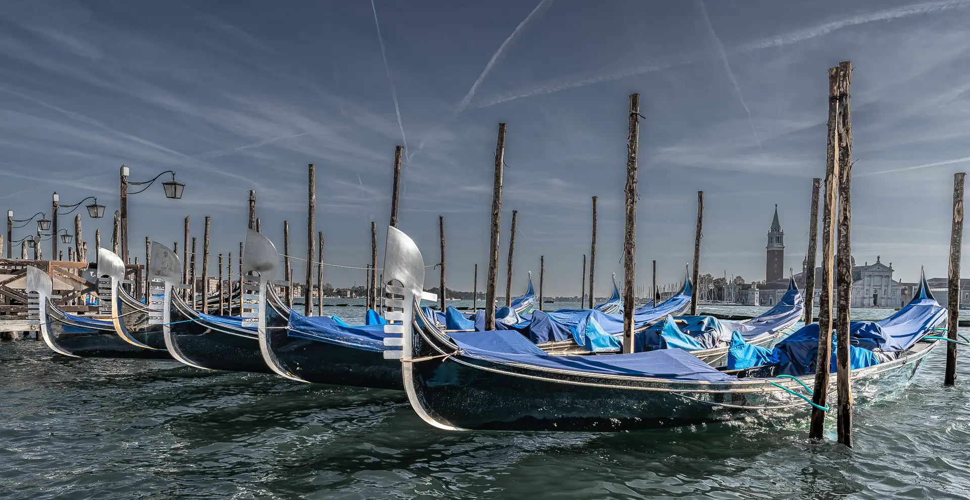 in San Marco sieht man geparkte Gondeln in einer Reihe die sonst in den magischen Wasserstraßen unterwegs sind